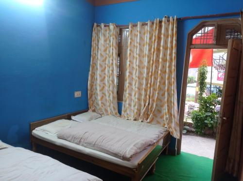 a small bed in a room with a window at Hotel diyaraj barkot sarukhet in Barkot