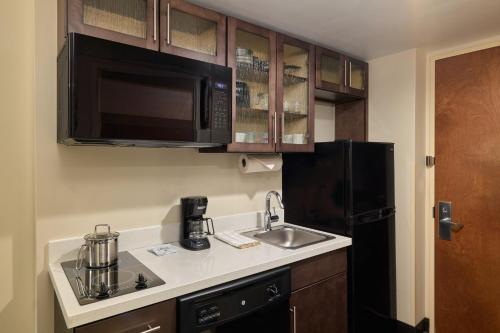 a kitchen with a sink and a black refrigerator at Candlewood Suites NYC -Times Square by IHG in New York