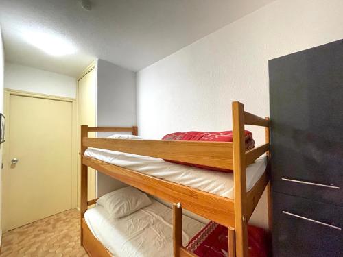 une chambre avec deux lits superposés et une commode dans l'établissement Studio à 50m de la plage avec parking privé, pour 4 personnes - FR-1-338-324, à Sète