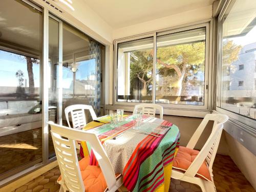 une salle à manger avec une table, des chaises et des fenêtres dans l'établissement Studio à 50m de la plage avec parking privé, pour 4 personnes - FR-1-338-324, à Sète