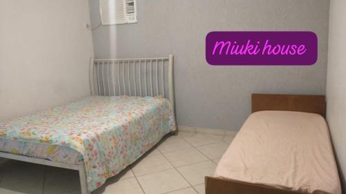 Una habitación con dos camas y un cartel que dice «Casa milagrosa». en Casa de Praia com Piscina em Peruíbe, en Peruíbe