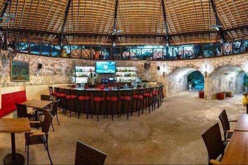 un restaurante con un bar con mesas y sillas en Orchid Inn en Montego Bay