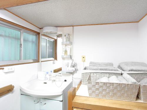 a bathroom with a sink and a bed in a room at GUESTHOUSE & SAUNA 杜（mori） in Kushimoto