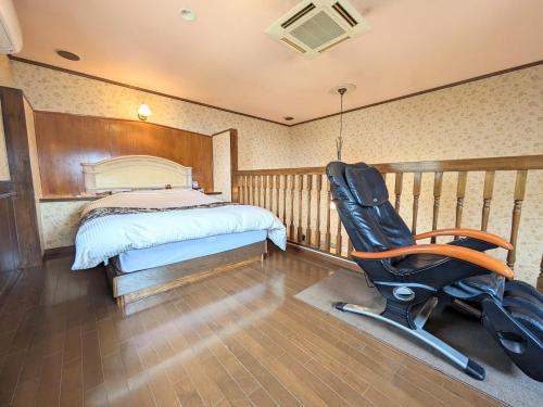 a bedroom with a bed and a desk and a chair at SKY Ocean-terace Omura in Omura
