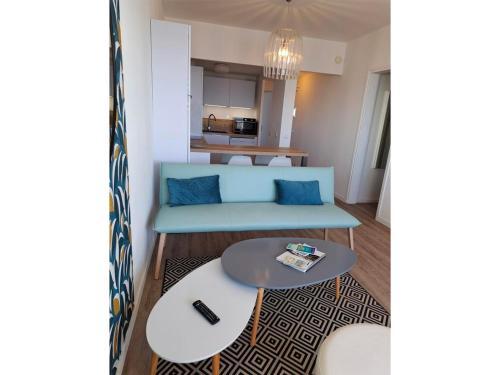 un salon avec un canapé bleu et une table dans l'établissement Appartement 2 Chambres - Dernier Étage - Terrasse Face Mer - Parking Sécurisé - FR-1-323-483, à Saint-Jean-de-Monts