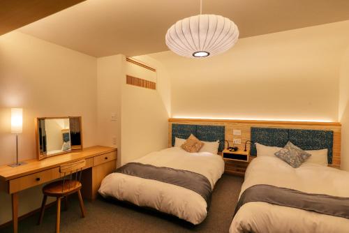 a hotel room with two beds and a mirror at Honjin Hiranoya Kachoan in Takayama