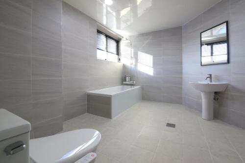 a white bathroom with a toilet and a sink at MGM Hotel in Gangneung