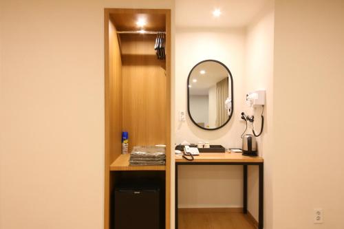 a bathroom with a vanity and a mirror at MGM Hotel in Gangneung