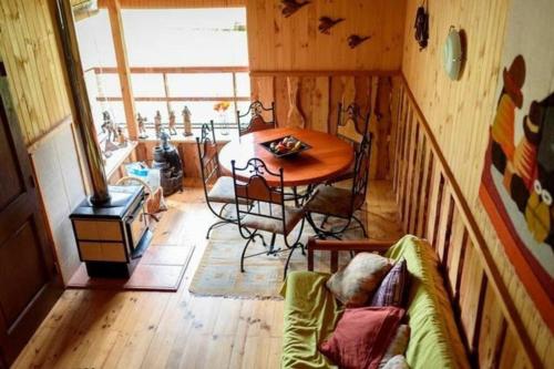 ein Wohnzimmer mit einem Tisch und einem Sofa in der Unterkunft Cabaña en Caburgua in Caburgua