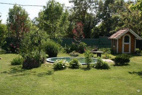 a backyard with a dog house and a pool at Malomdűlő Farmház in Pilisborosjenő