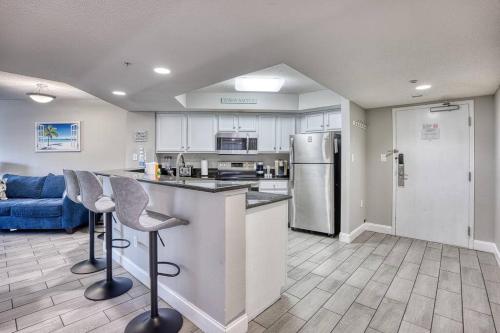 a kitchen with two bar stools and a refrigerator at Oceanview Paradise at the Beach in Myrtle Beach