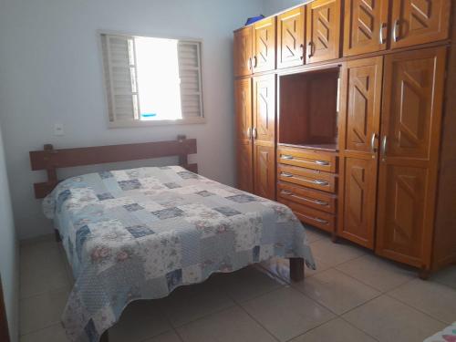 um quarto com uma cama, uma cómoda e uma televisão em Casa Maria em Pirenópolis