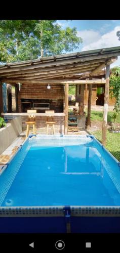 uma grande piscina azul em frente a uma casa em Cabañas Guaimbe em Eldorado
