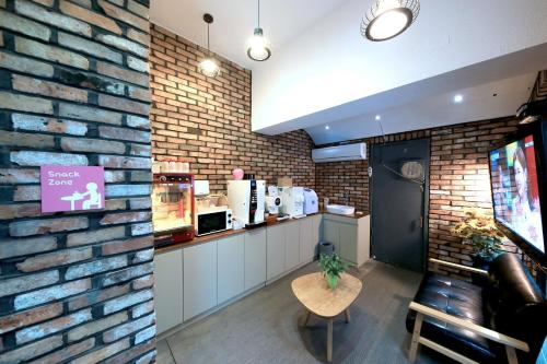 a brick wall in a restaurant with a counter and a table at Hotel Yaja Cheongju Terminal Branch in Cheongju