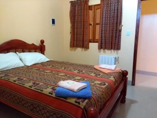 1 dormitorio con 1 cama con toallas en HOSTAL DOÑA BERTA en Humahuaca