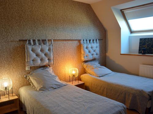 um quarto com 2 camas, uma janela e 2 candeeiros em Gîte Oinville-Saint-Liphard, 3 pièces, 4 personnes - FR-1-581-23 