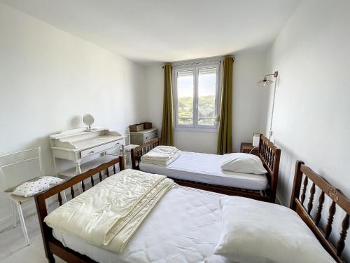 1 Schlafzimmer mit 2 Betten, einem Waschbecken und einem Fenster in der Unterkunft Appartement Donville-les-Bains, 3 pièces, 4 personnes - FR-1-361-433 in Donville-les-Bains