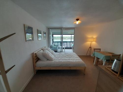 une chambre avec un lit et une télévision dans l'établissement Studio moderne rénové au bord du lac pour deux personnes à Vieux Boucau - FR-1-239-991, à Soustons