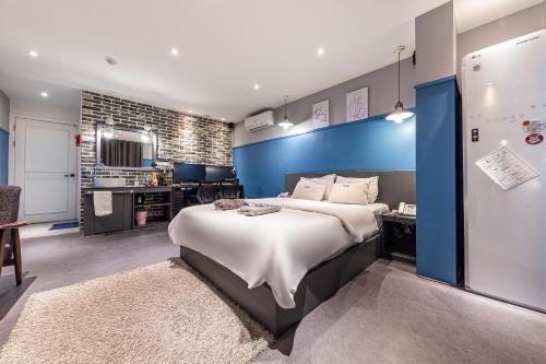 a bedroom with a large bed with a blue wall at Hotel Yaja Cheongju Terminal Branch in Cheongju