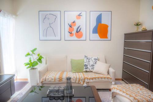 a living room with a couch and pictures on the wall at 富士見台駅6分 貸切最大人数11名 池袋15分 寝室5つ シャワールーム2つ ハリーポッタースタジオ近 喫煙可 in Tokyo