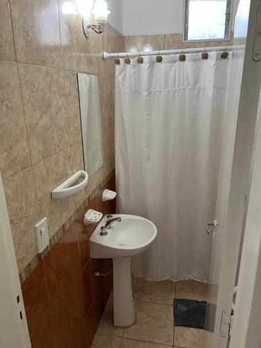 y baño con lavabo blanco y ducha. en Bella Luna apart en Mina Clavero