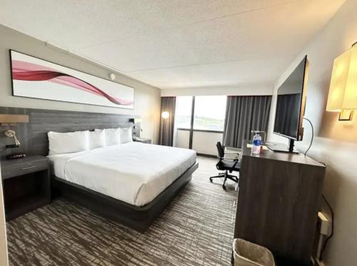um quarto de hotel com uma cama e uma televisão em Kiteville Cedar Rapids em Cedar Rapids