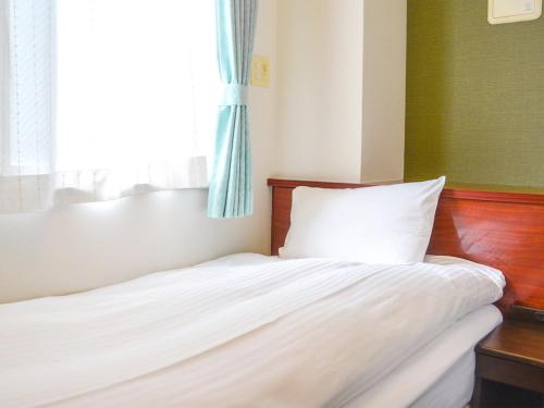 Bett in einem Zimmer mit Fenster in der Unterkunft WEB Hotel Tokyo Asakusabashi - Vacation STAY 13758v in Tokio