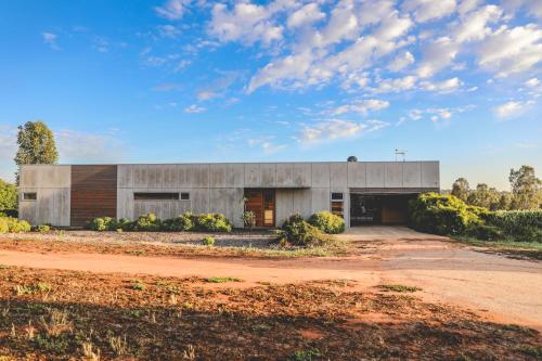 a large concrete building on a dirt road at Luxury Retreat at Barham Avocados in Barham