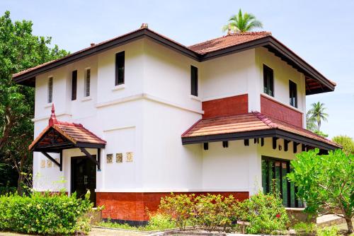 a white house with a brown roof at Banyu Biru Villa in Lagoi