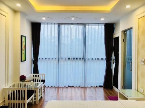 a living room with a large window with curtains at Lotus Hotel - A24, Khu Đấu Giá, Vạn Phúc - by Bay Luxury in Hà Ðông