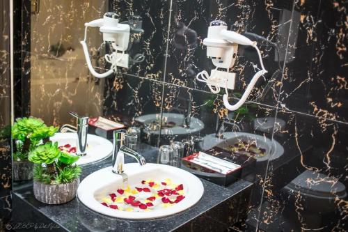 a bathroom with two sinks with flowers in it at Lotus Hotel - A24, Khu Đấu Giá, Vạn Phúc - by Bay Luxury in Hà Ðông