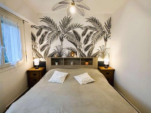 - une chambre avec un grand lit orné d'une fresque murale représentant la plante dans l'établissement Appartement rénové à Fouesnant, 4 pers. à 50m de la plage de Cap Coz, parking privé - FR-1-481-155, à Fouesnant