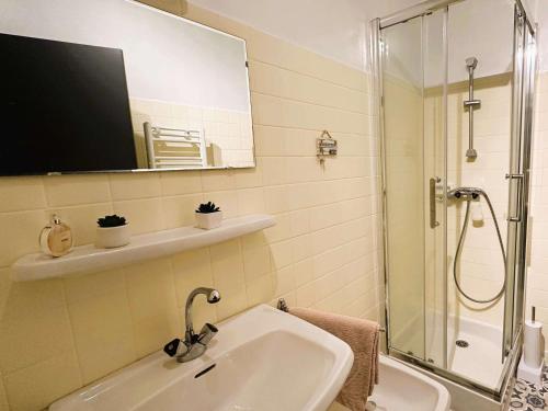 une salle de bain avec un lavabo, une douche et un miroir dans l'établissement Appartement rénové à Fouesnant, 4 pers. à 50m de la plage de Cap Coz, parking privé - FR-1-481-155, à Fouesnant
