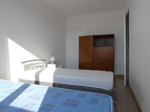- une chambre avec deux lits et une armoire dans l'établissement Maison 2 chambres près plage et commerces, quartier calme, parfait pour 5 pers, parking privé. - FR-1-323-366, à Saint-Jean-de-Monts