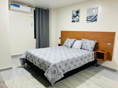 - une chambre avec un grand lit et une tête de lit en bois dans l'établissement Estudio aeropuerto, à Ciudad Juárez