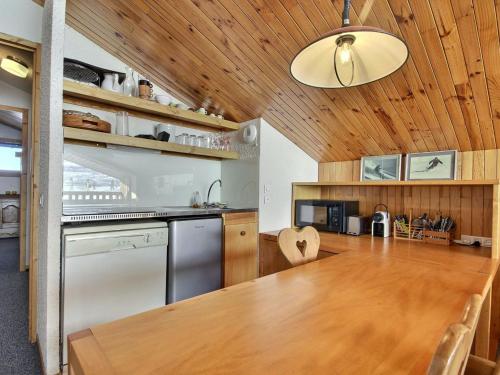 une cuisine avec un plafond en bois et une table en bois dans l'établissement Appartement 2 pièces avec balcon et vue sur pistes, animaux admis - FR-1-455-252, à La Plagne Tarentaise