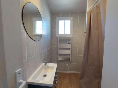 une salle de bain avec un lavabo et un miroir dans l'établissement Appartement 4 pièces à Marseillan Plage, proche de la mer, avec parking et équipements complets - FR-1-326-799, à Marseillan