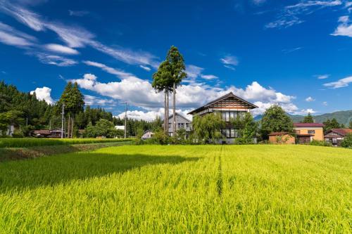 un campo de arroz frente a una casa en Sakadojo, en Minami Uonuma