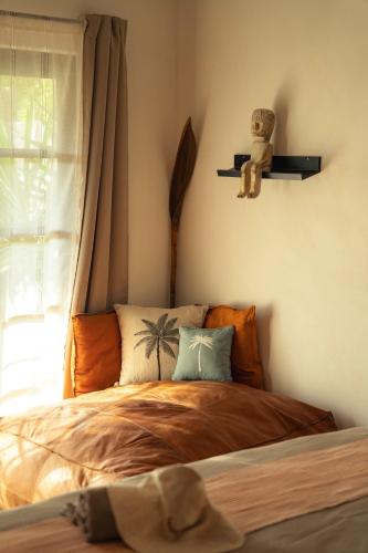 ein Schlafzimmer mit einem Bett mit einem Teddybär auf einem Regal in der Unterkunft Casa MexiBali, Suite Mexi in Troncones