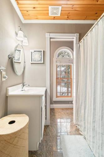 a bathroom with a sink and a mirror and a window at Spacious Lakefront Retreat w/Stunning Views in Hinesburg