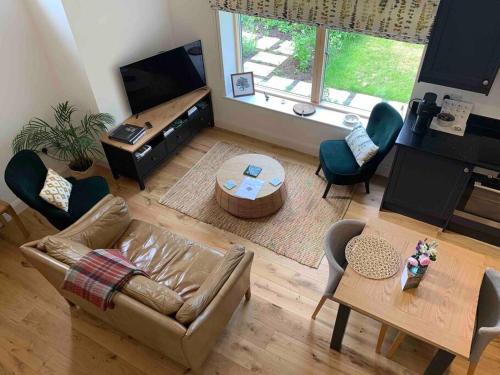 a living room with a couch and a table at Private 2 Bedroom Apartment at Woodland Retreat in Gamlingay