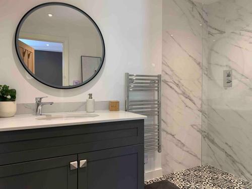 a bathroom with a sink and a mirror at Private 2 Bedroom Apartment at Woodland Retreat in Gamlingay