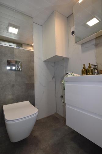 bagno con servizi igienici bianchi e lavandino di Prześpij się z Alpaką w Tiny House 