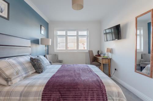 a bedroom with a large bed and a mirror at Apple House Wembley -Double Ensuite in Edgware