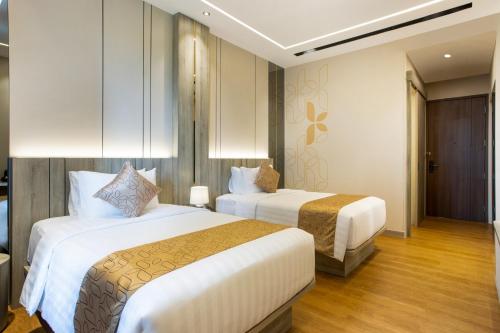 a hotel room with two beds in a room at Kinaralana Hotel Yogyakarta in Yogyakarta