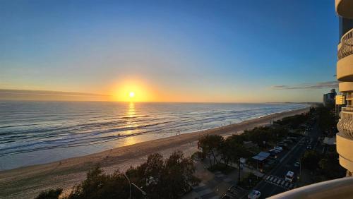 a view of the beach at sunset from a building at Olympus Beachfront Apartments in Gold Coast