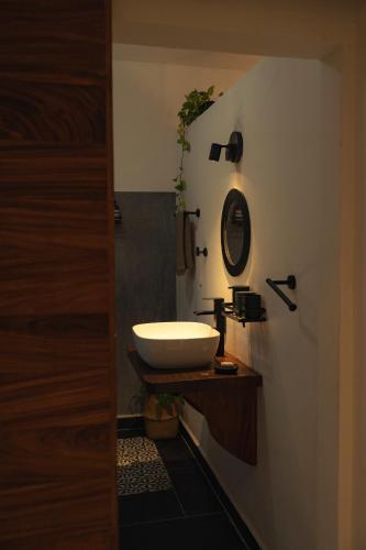 a bathroom with a white sink on a wooden counter at Casa Mexibali, Suite Bali in Troncones