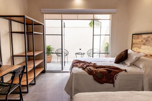 een slaapkamer met een bed en uitzicht op een patio bij Hotel Casa María Teresa in León