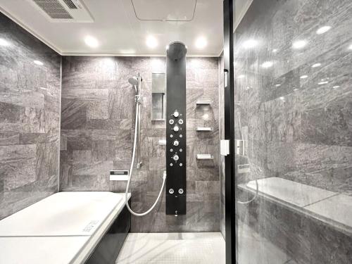 a bathroom with a shower and a bath tub at S-asakusa in Tokyo
