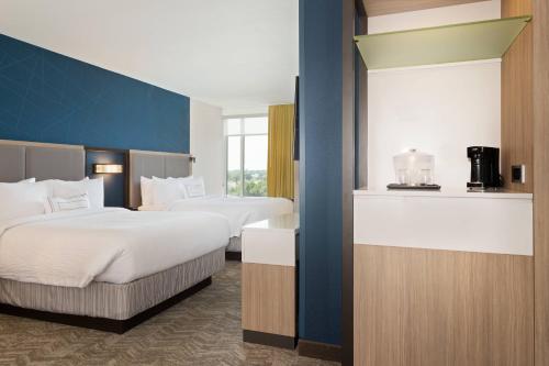 SpringHill Suites by Marriott Ocala في أوكالا: غرفة فندقية بسريرين ونافذة